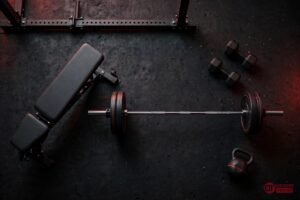 RitFit home gym equipment flat lay with power rack, weight bench, barbell and dumbbells
